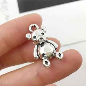 Macro detail of a cute 3D antique silver teddy bear alloy pendant with a hanging ring