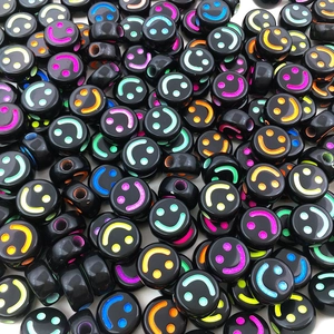 Detailed macro view of black acrylic smile beads with colorful patterns for DIY jewelry