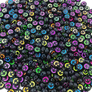 Close-up of black acrylic beads with colorful fluorescent smiley faces for DIY jewelry