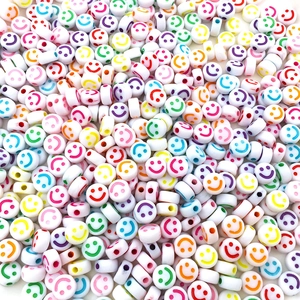Macro shot of white acrylic beads with colorful smiley face prints for DIY jewelry making