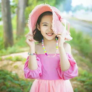 Detailed view of a child wearing a colorful acrylic smiley bead necklace and bracelet set