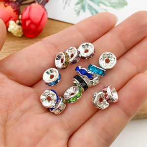 Macro shot of colorful rondelle spacer beads with crystal rhinestones held in a hand
