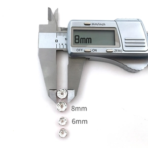 Macro detail showing 6mm and 8mm silver spacer beads with rhinestones on a digital caliper