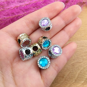 Macro shot of large hole charms with colorful oval gemstones and zircon accents