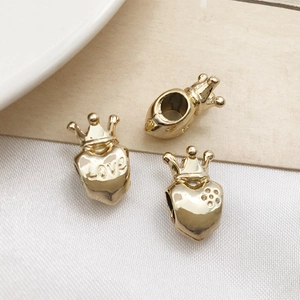 Macro detail of golden alloy heart and crown large hole charms for DIY jewelry making