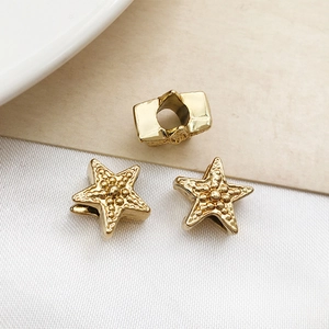 Macro view of gold starfish alloy beads with embossed dots for DIY jewelry making
