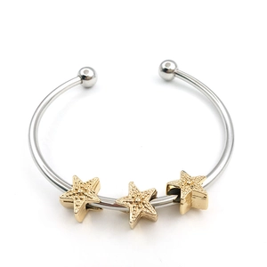 Polished silver metal bangle with three textured gold star charms on a white background