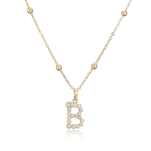 Dettaglio della collana con pendente lettera B dorata con zirconi tondi e sfere