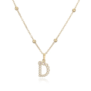 Dettaglio della collana con pendente a lettera D dorata con zirconi bianchi e perle