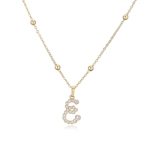 Dettaglio del ciondolo lettera E dorata con pavé di cristalli e catena a sfere elegante