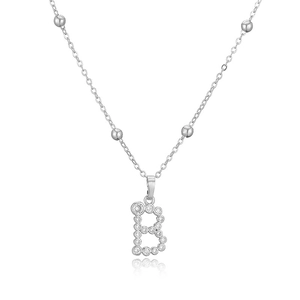 Dettaglio macro della collana con ciondolo lettera B argento con pavé di zirconi e perle