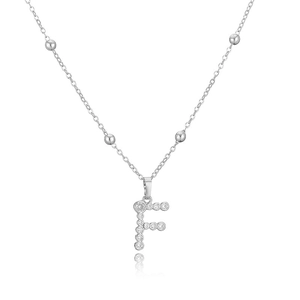 Dettaglio della collana argentata con pendente lettera F in zirconi e catena a sfere