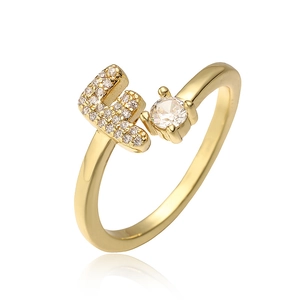 Detail van gouden letter F ring met zirkonia micro-pave en ronde centrale steen