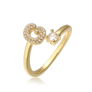 Macro-detail van gouden letter G ring met micro-pave en een ronde solitaire zirkonia