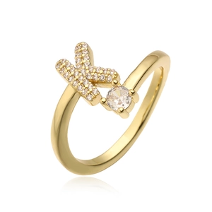 Macro-opname van gouden letter K ring met zirkonia-pavee en een ronde solitaire steen