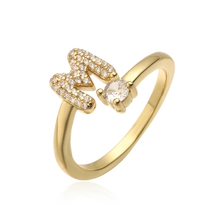 Detail van de goudkleurige letter M ring met zirkonia pavé en ronde centrale edelsteen