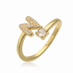 Gedetailleerde macro van gouden letter M ring met zirkonia micropavé en grote ronde steen
