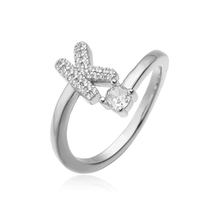 Macro-detail van zilveren ring met pavé-zirkonia letter X en een solitair steen in vier-klauw