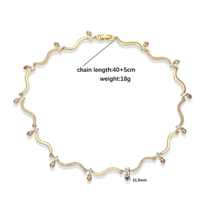 Golden wavy chain necklace with heart charms and cubic zirconia stones in a flat lay view