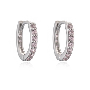 Close-up of silver huggie hoop earrings featuring a row of inlaid pink cubic zirconia