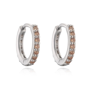 Silver huggie hoop earrings with sparkling amber stones shown on white reflective background
