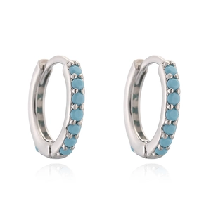 Detail of silver earrings featuring track-set round sky blue stones in a 12mm hoop design