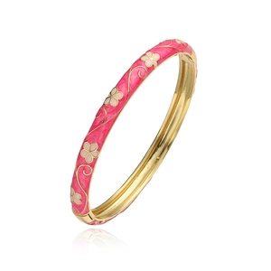 Détail d'un bracelet jonc en émail rose avec motifs de vignes dorées vintage