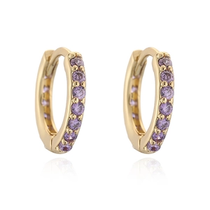 Detailed macro view of golden huggie earrings set with round purple zircons