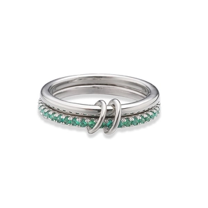 Macro view of interlocking silver rings with emerald green zircon paving and dual-band style