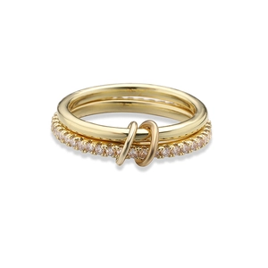 Detailed close-up of double-linked gold rings with pavé set crystals on white background
