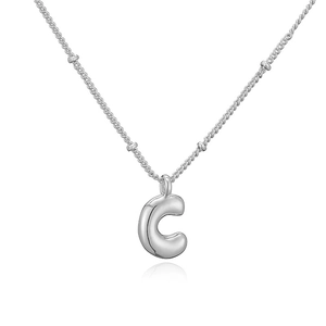 Dettaglio macro del ciondolo lettera C argento stile bubble su una collana con palline