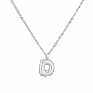 Vista macro della collana con ciondolo lettera D d'argento con catena a maglie di perle