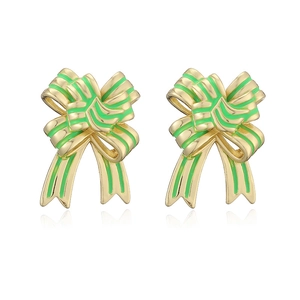 Detail of gold bow earrings with green striped enamel work on white background