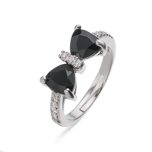 Detailed macro view of a silver bow ring with black gems and micro-pave white crystals