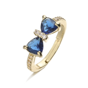 Macro shot of luxury gold-plated bow ring featuring deep blue sapphire-like crystals