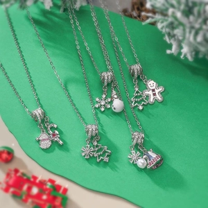 Colliers de Noël exquis avec pendentifs flocons et cloches sur décor festif vert