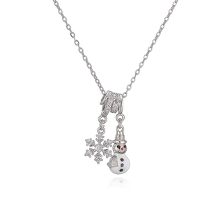 Gros plan de pendentifs flocon et bonhomme de neige sur collier argenté raffiné