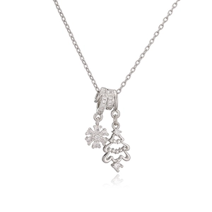 Collier argenté avec pendentifs flocon de neige et sapin de Noël sur fond blanc