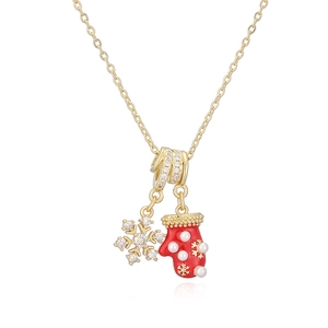 Détail du collier de Noël doré avec flocon de cristal et breloque gant rouge
