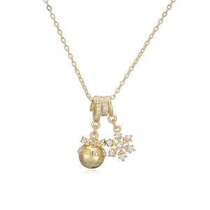 Détail du collier de Noël avec pendentif flocon et boule dorée gravée Merry Christmas