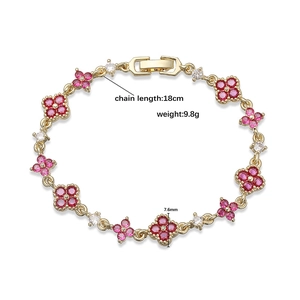 Luxury gold-tone four-leaf clover bracelet with sparkling red crystals and small diamonds