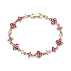 Detailed close-up of a gold-plated flower bracelet with red and white zircon inlays
