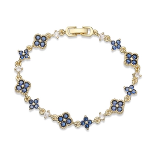 Detailed close-up of golden clover bracelet with inlaid blue and white crystals