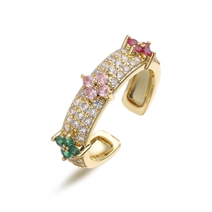 Close-up of golden adjustable clover ring with pink and green pavé set gemstones