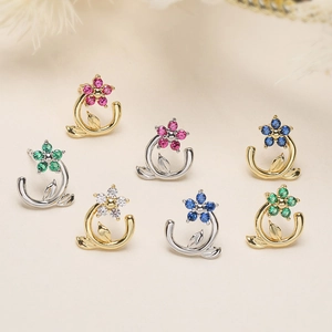 Detailed close-up of crystal camellia earrings in various colors with gold and silver finish