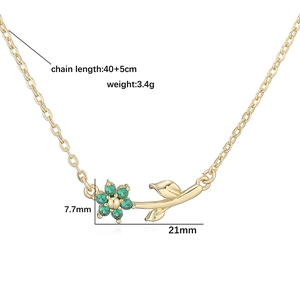 Golden camellia necklace with green gemstone flower pendant and leaf detail
