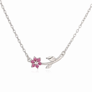 Detailed macro of floral necklace with pink crystals and silver metal leaf pendant