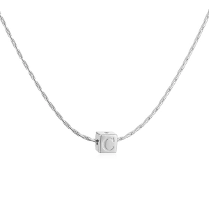Gros plan d'un pendentif cube argenté avec lettre C gravée sur une fine chaîne maille