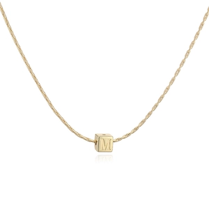 Gros plan du pendentif cube en or 18 carats avec la lettre M sur une chaîne maille