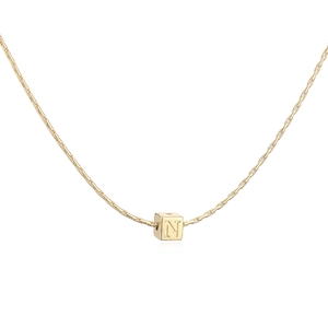 Détail macro du pendentif carré plaqué or 18 carats avec une lettre N gravée minimaliste